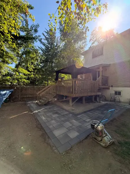 Paver patio beside the raised backyard deck