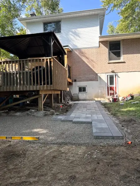 Deck and freshly laid paver base mid-build