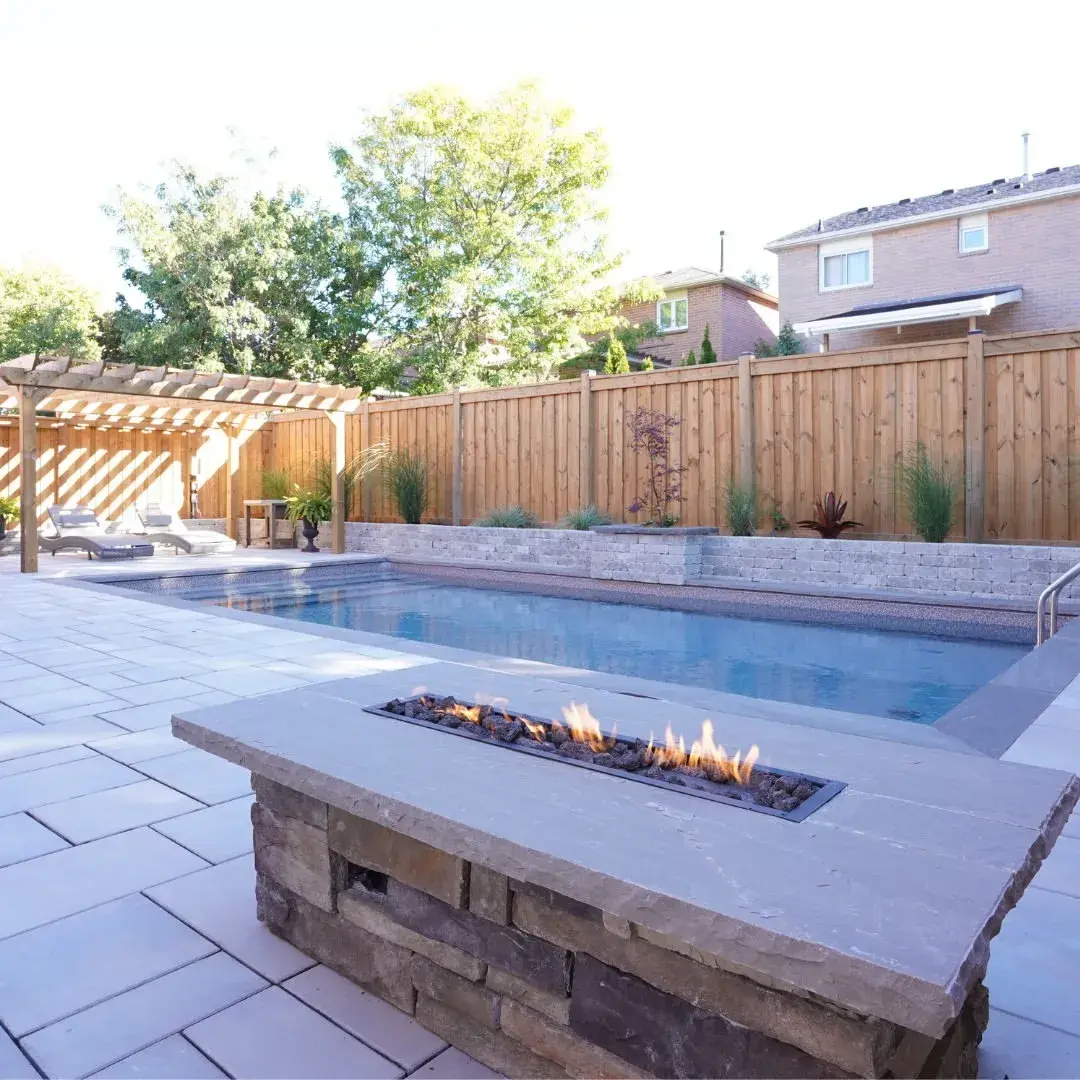 Pool with a stone fire feature and paver patio