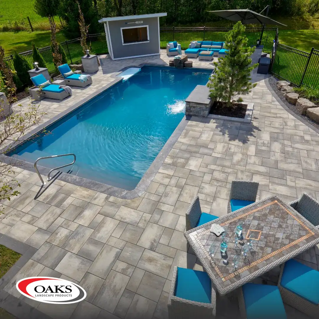 An MWG pool and patio carrying the Oaks Landscape Products badge