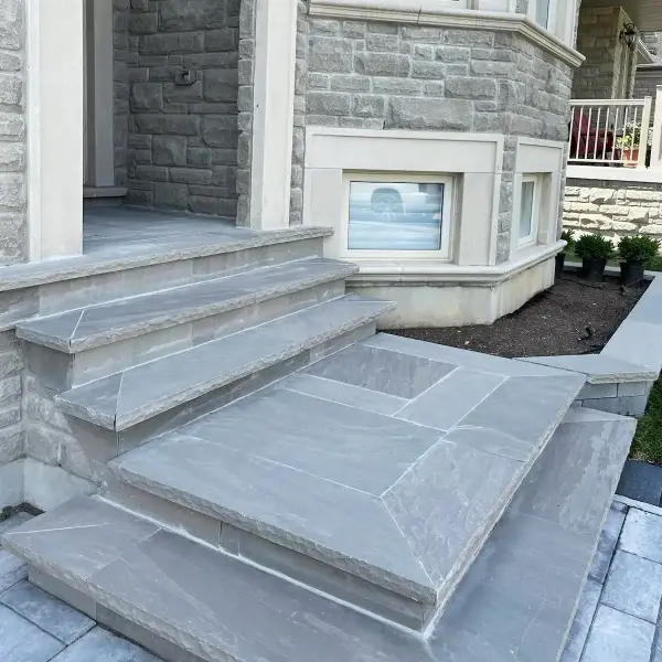 Wide natural-stone steps beside a stone-clad wall