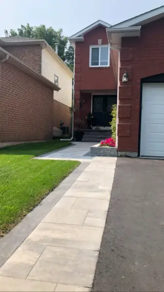 Paver walkway beside the garage with fresh sod