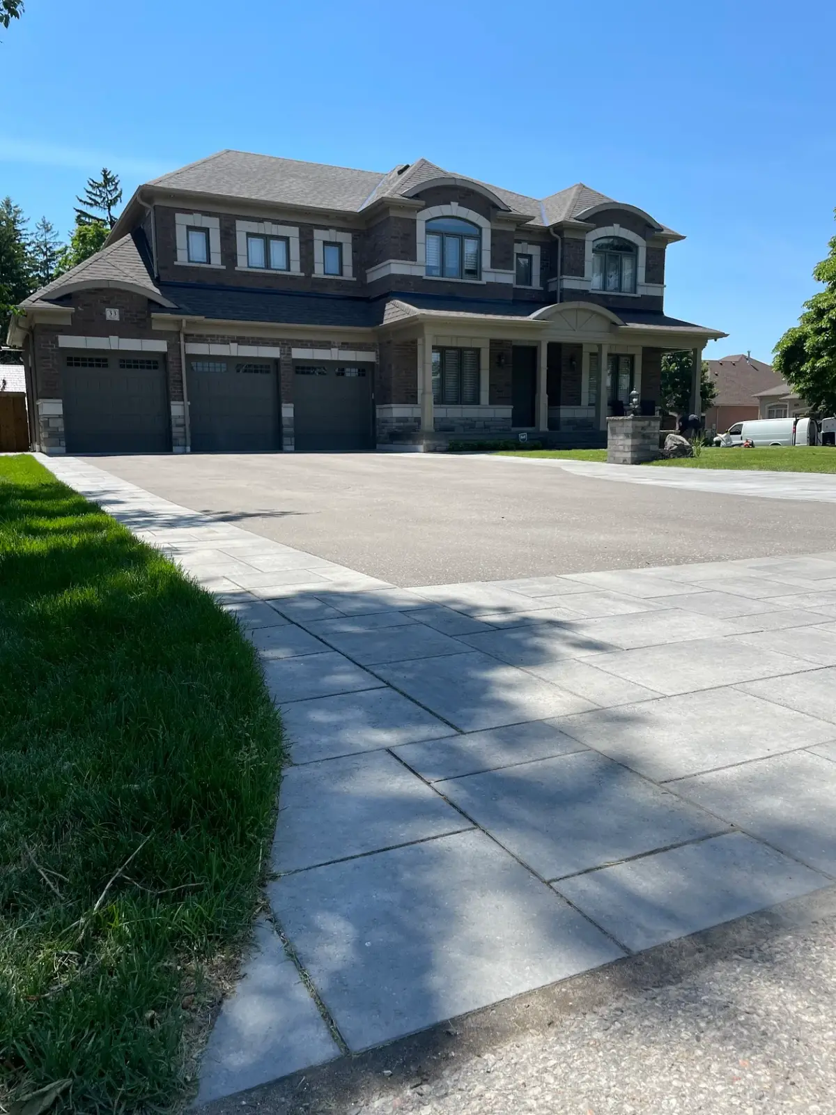 Wide paver driveway and front entrance at a large home
