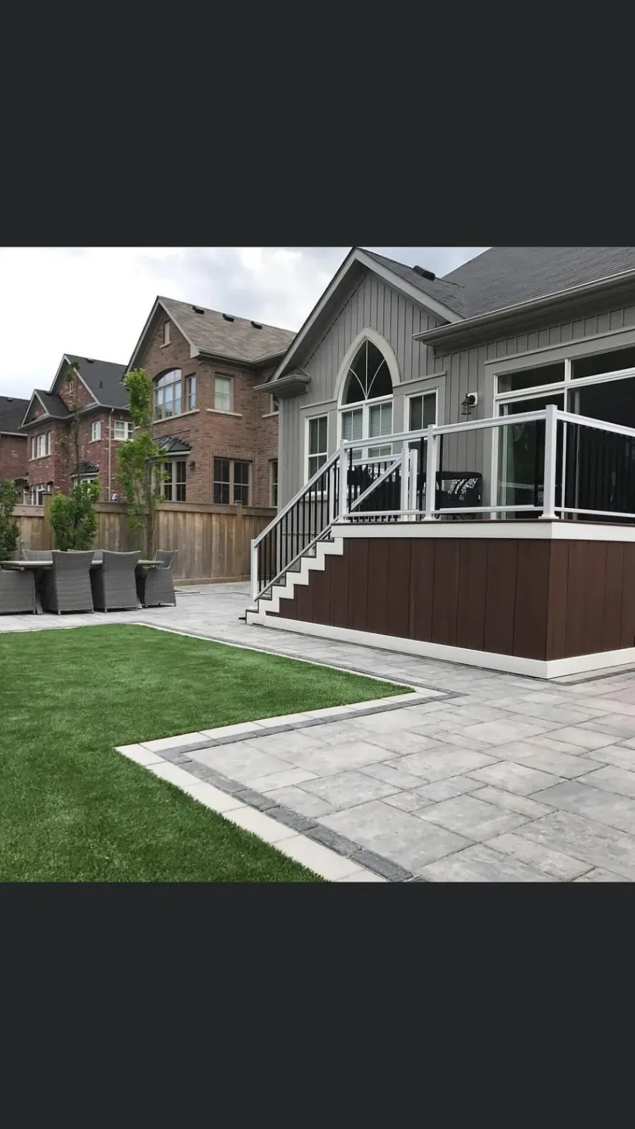 Raised back patio with a deck and glass railing