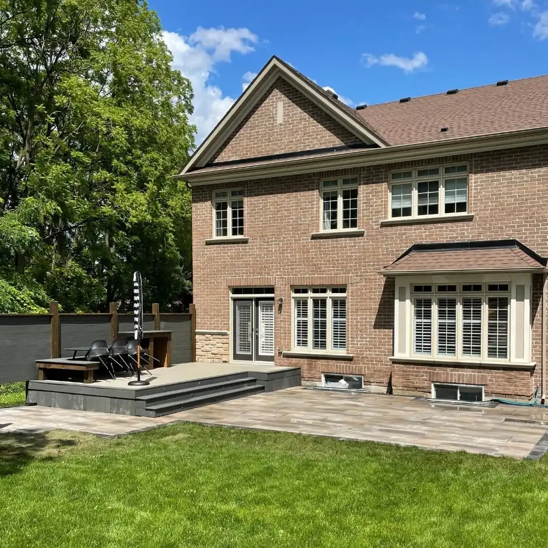 Large-format paver patio behind a brick home
