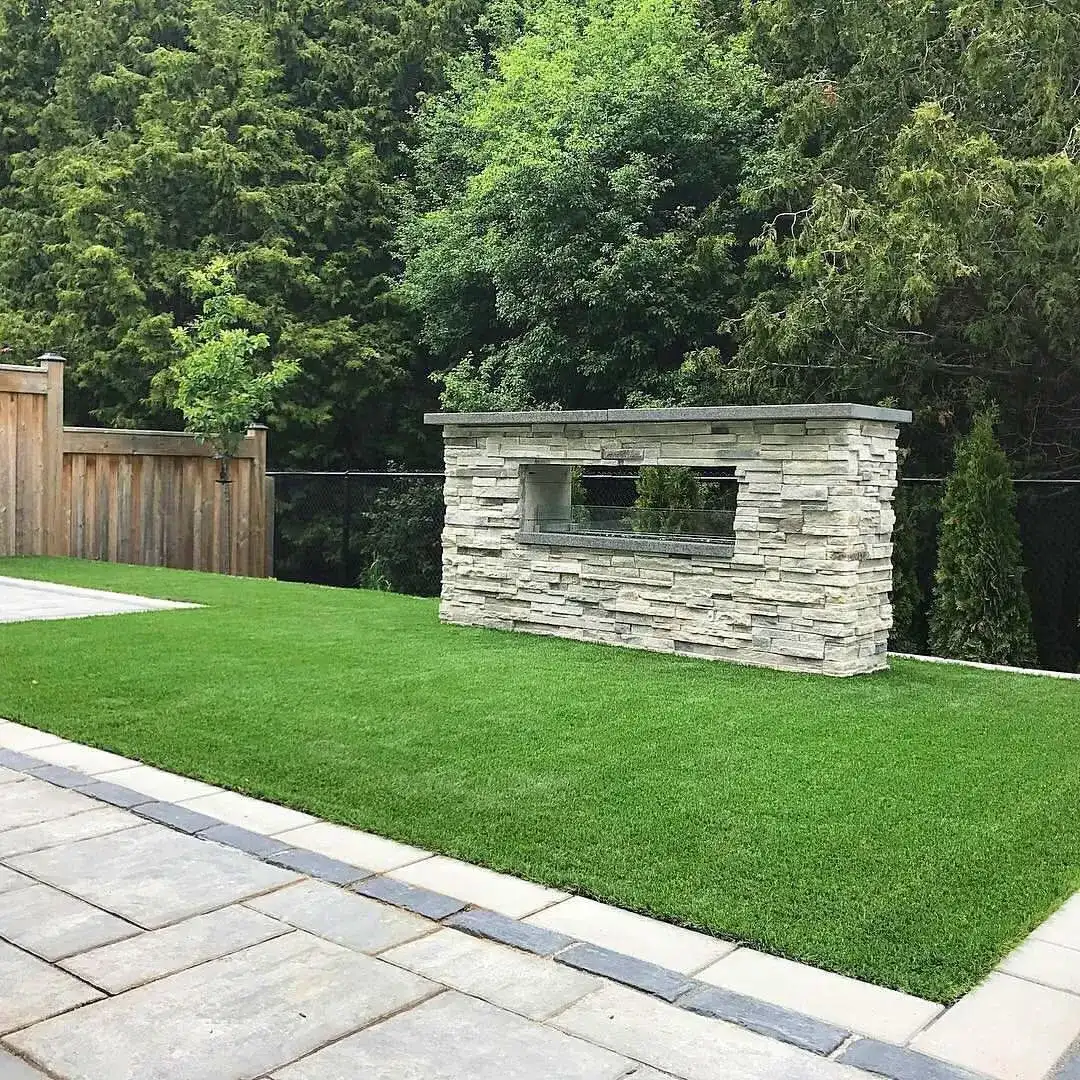 Stacked-stone outdoor fireplace on artificial turf