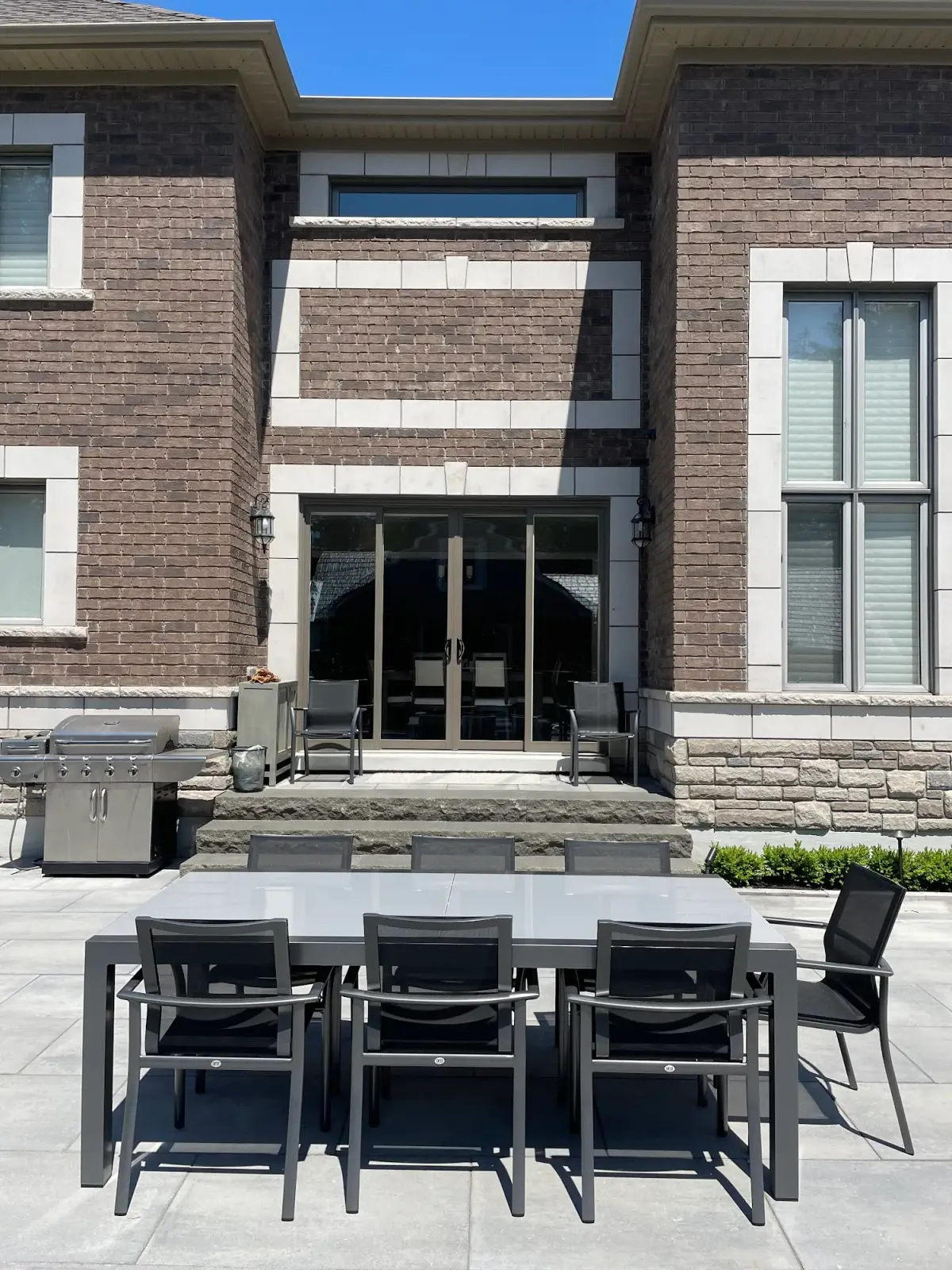 Outdoor kitchen and dining area on a paver patio