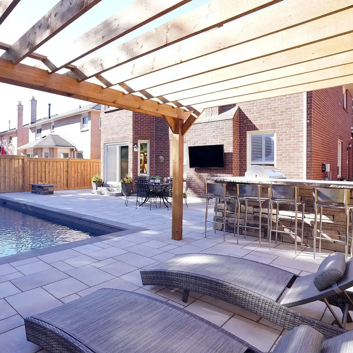 Wood pergola with a bar beside a pool