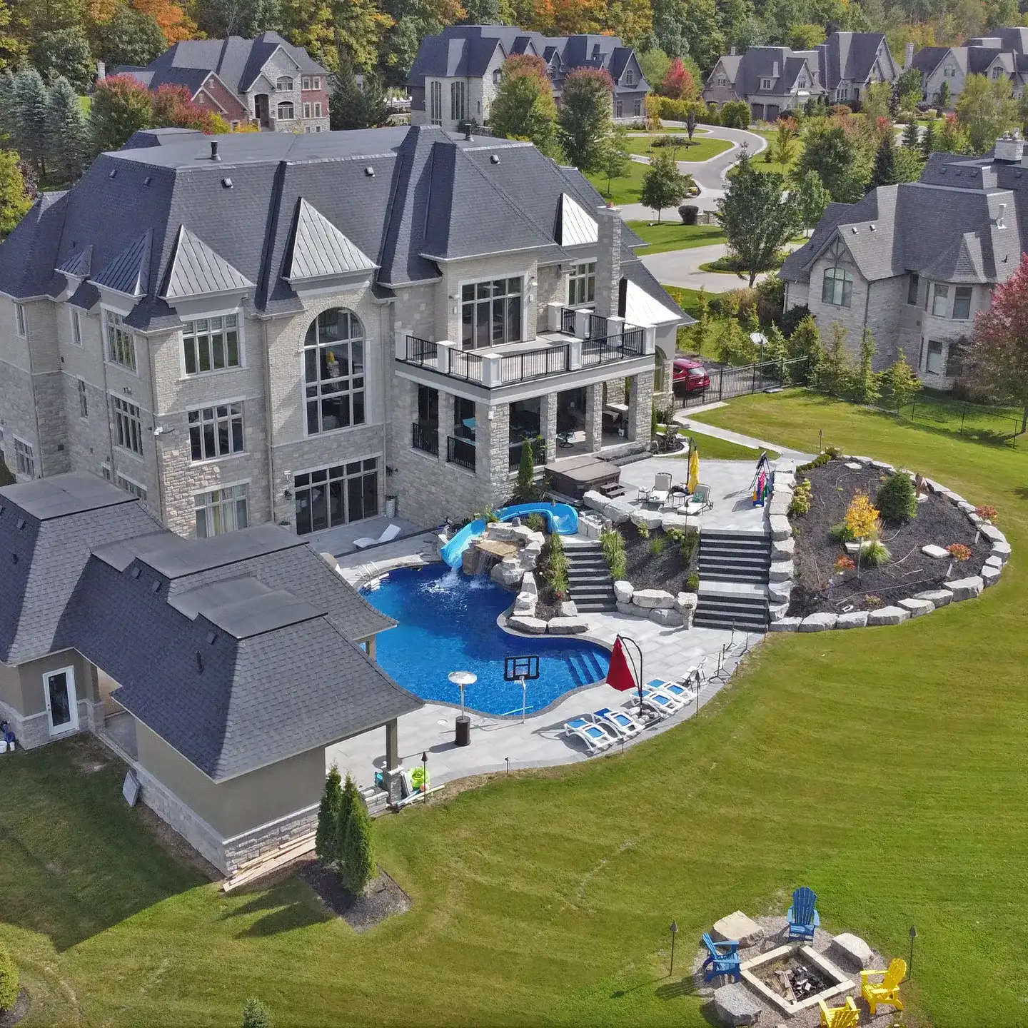 Aerial view of the full grotto backyard with its pool, slide and gardens