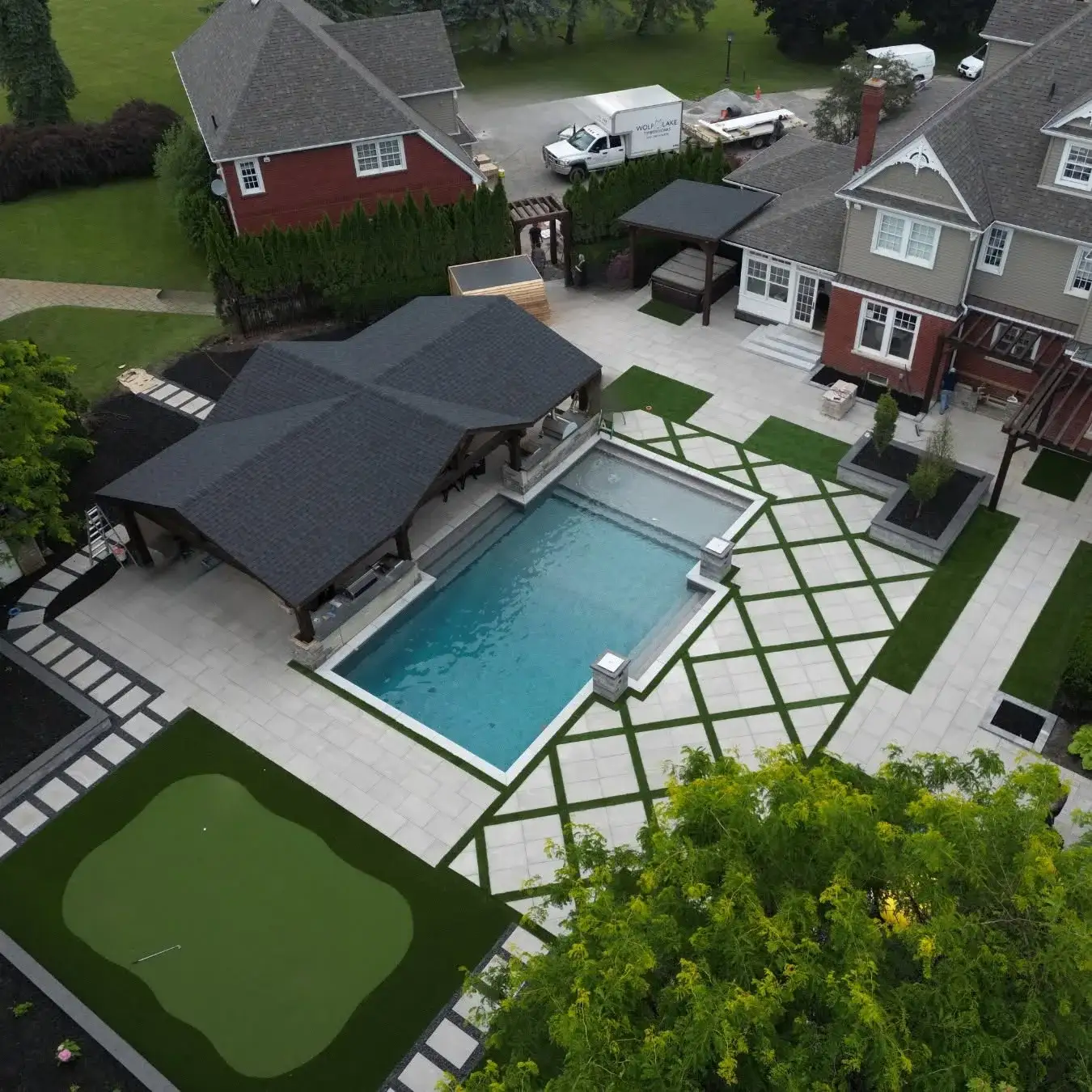 Aerial of a resort backyard with pool, pavilion and putting green