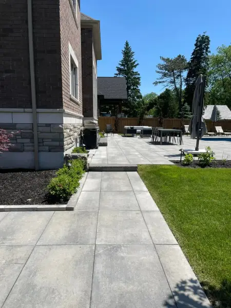 Paver walkway and fresh plantings along the house