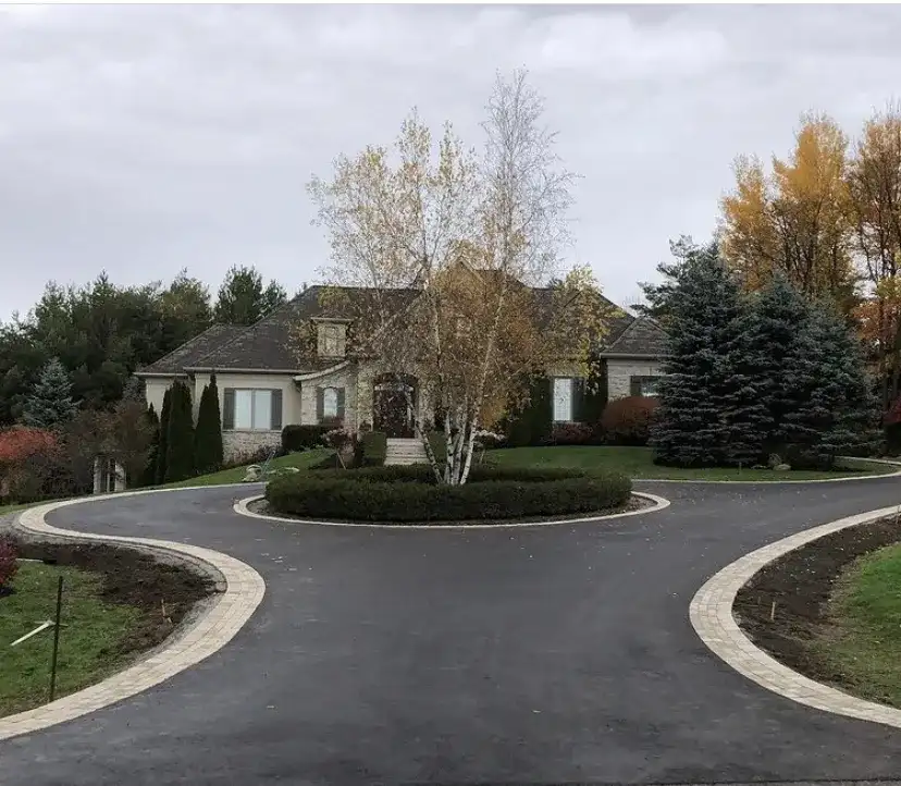 Circular asphalt drive ringed in pavers