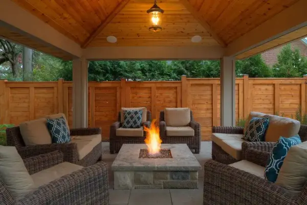 Covered pavilion with a fire table after dark