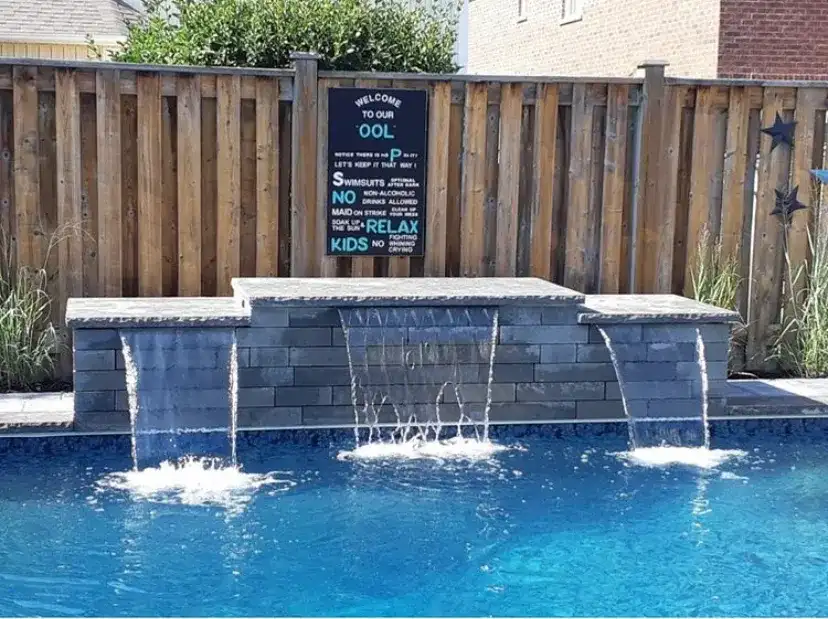 Sheer-descent water wall spilling into the pool